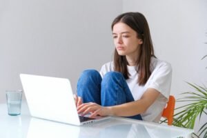 a female typing on laptop researching